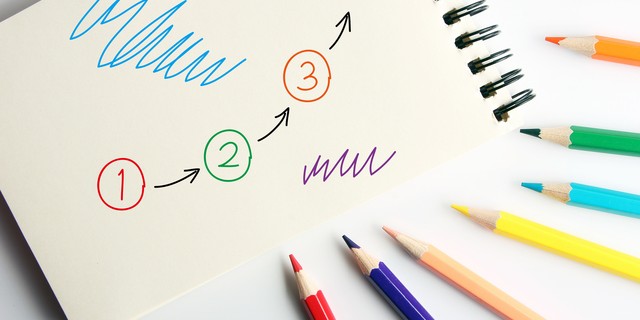 Business concept drawing on the paper with color pencils aside.