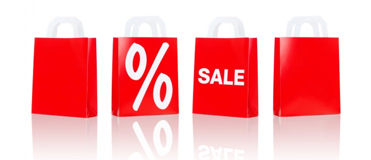 sale, consumerism, discount, advertisement and retail concept - many red shopping bags with percentage sign