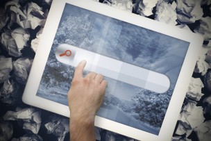 Hands touching search bar on tablet screen on crumpled up paper