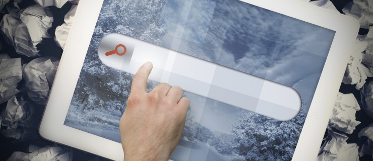 Hands touching search bar on tablet screen on crumpled up paper